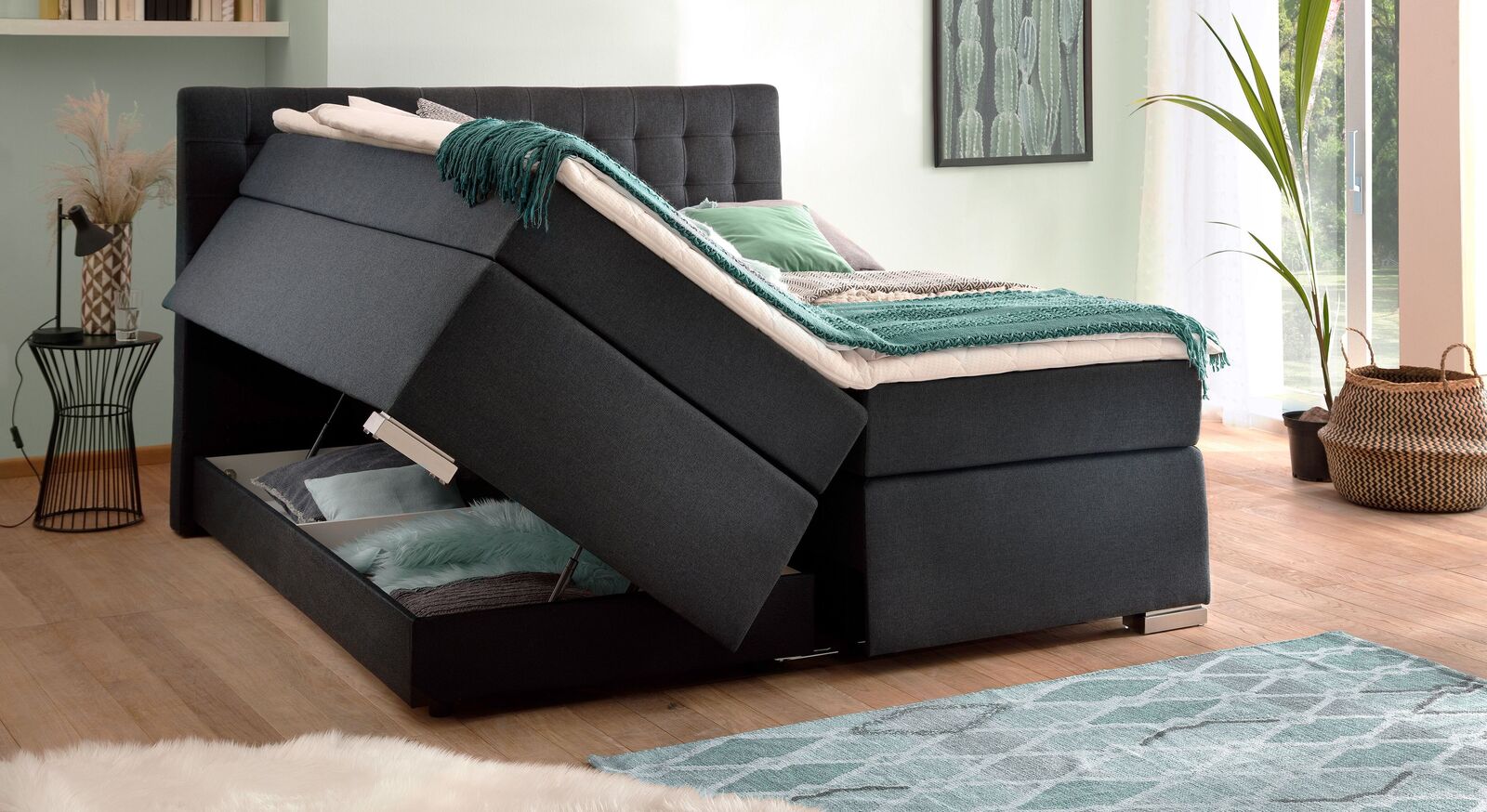 Sie erhalten das Boxspringbett in diversen Bezugsarten und Farben – hier in anthrazitfarbenem Velours-Webstoff mit Füßen in Edelstahloptik.