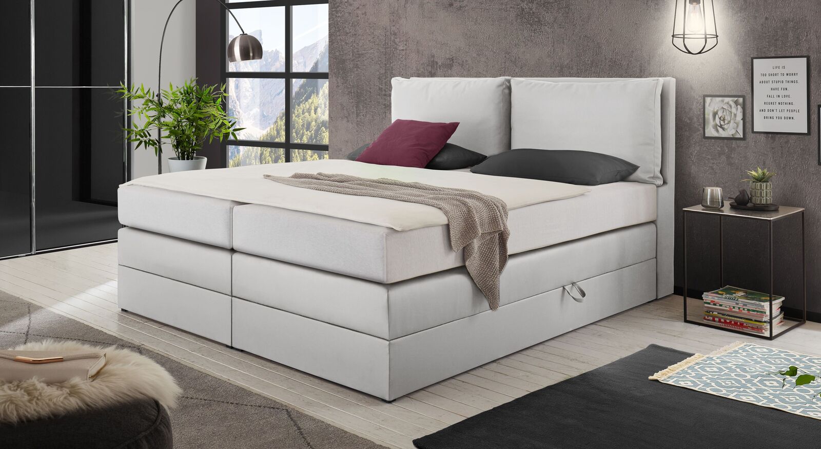 Das Bettkasten-Boxspringbett "Elenor" mit weißem Kunstlederbezug.