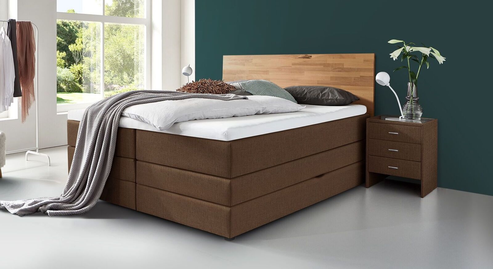 Für eine besonders warme Ausstrahlung des Bettkasten-Boxspringbettes "Peachland" sorgen Sie mit dem braun melierten Webstoff.