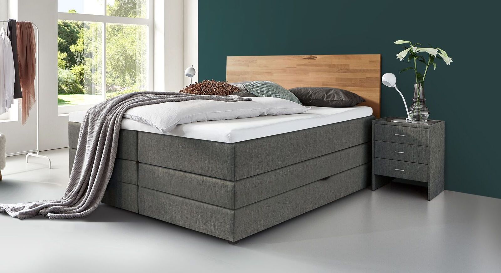 Klassisch und zeitlos elegant wirkt das Bettkasten-Boxspringbett "Peachland" mit grau meliertem Webstoff als Bezug.