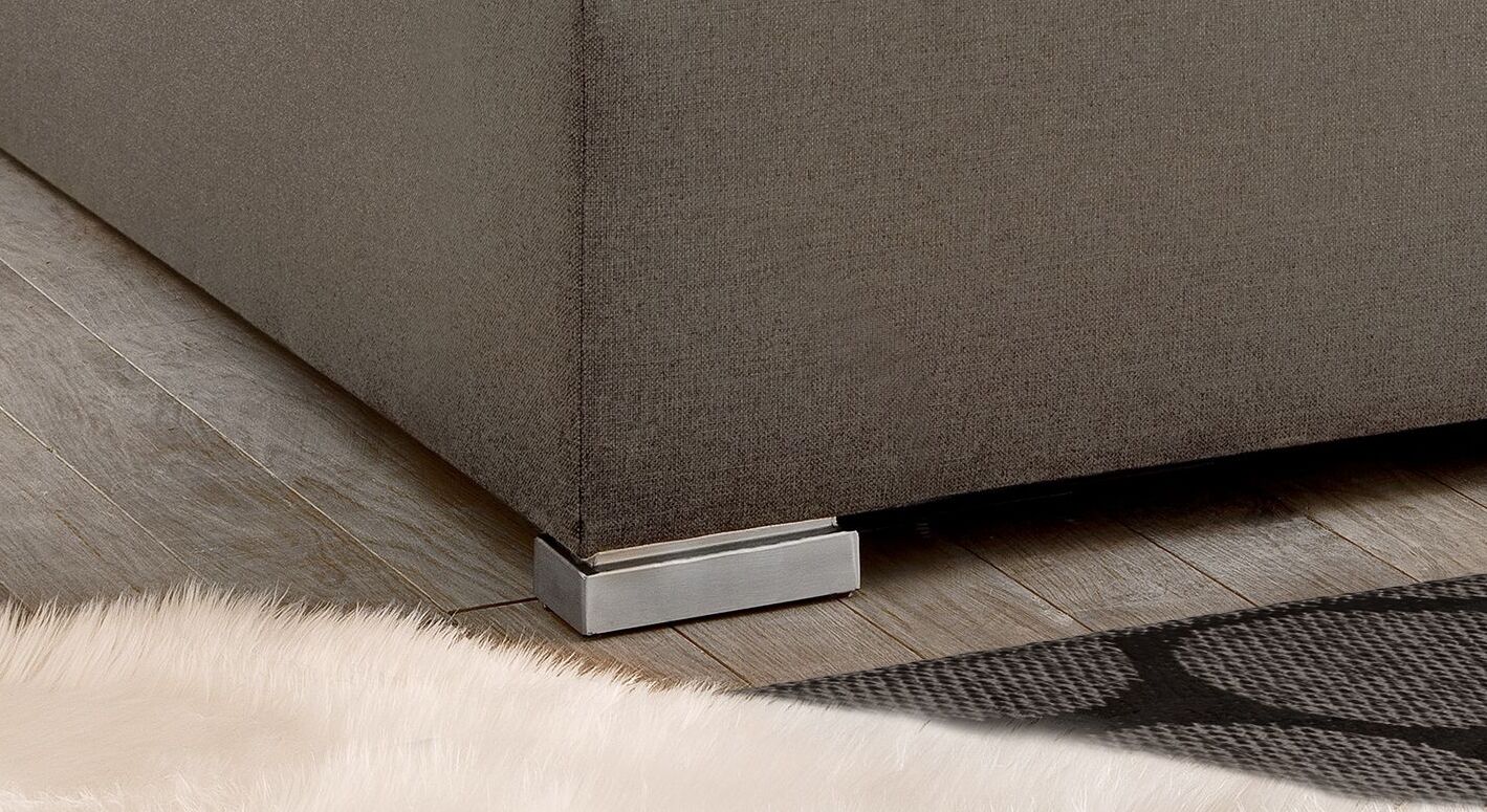 Einen eleganten Kontrast zum klassischen Bettdesign bilden die modernen Blockfüße aus gebürstetem Metall.