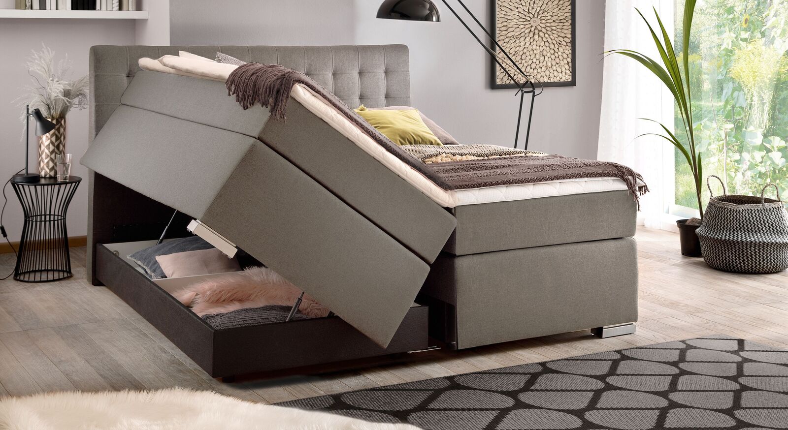 Auf jeder Bettseite befindet sich ein geräumiger Bettkasten unter dem Boxspringsystem, der sich dank Gasdruckfedern besonders leicht öffnen lässt.