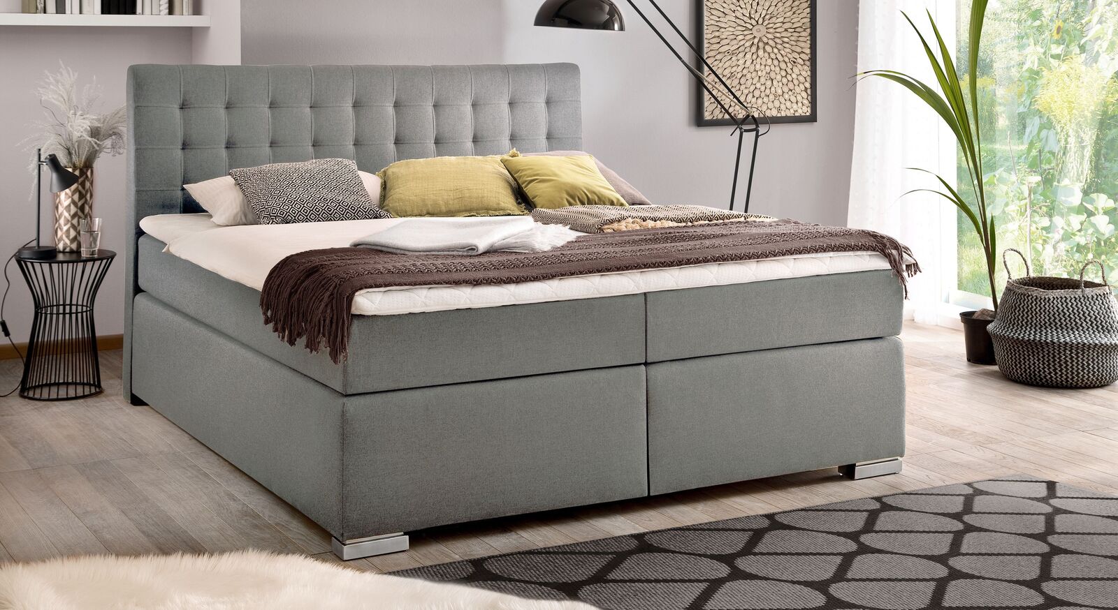 Genießen Sie erholsame Nächte in Ihrem neuen Bettkasten-Boxspringbett "Santera" – hier mit grauem und gröberem Webstoff-Bezug sowie Metallfüßen.