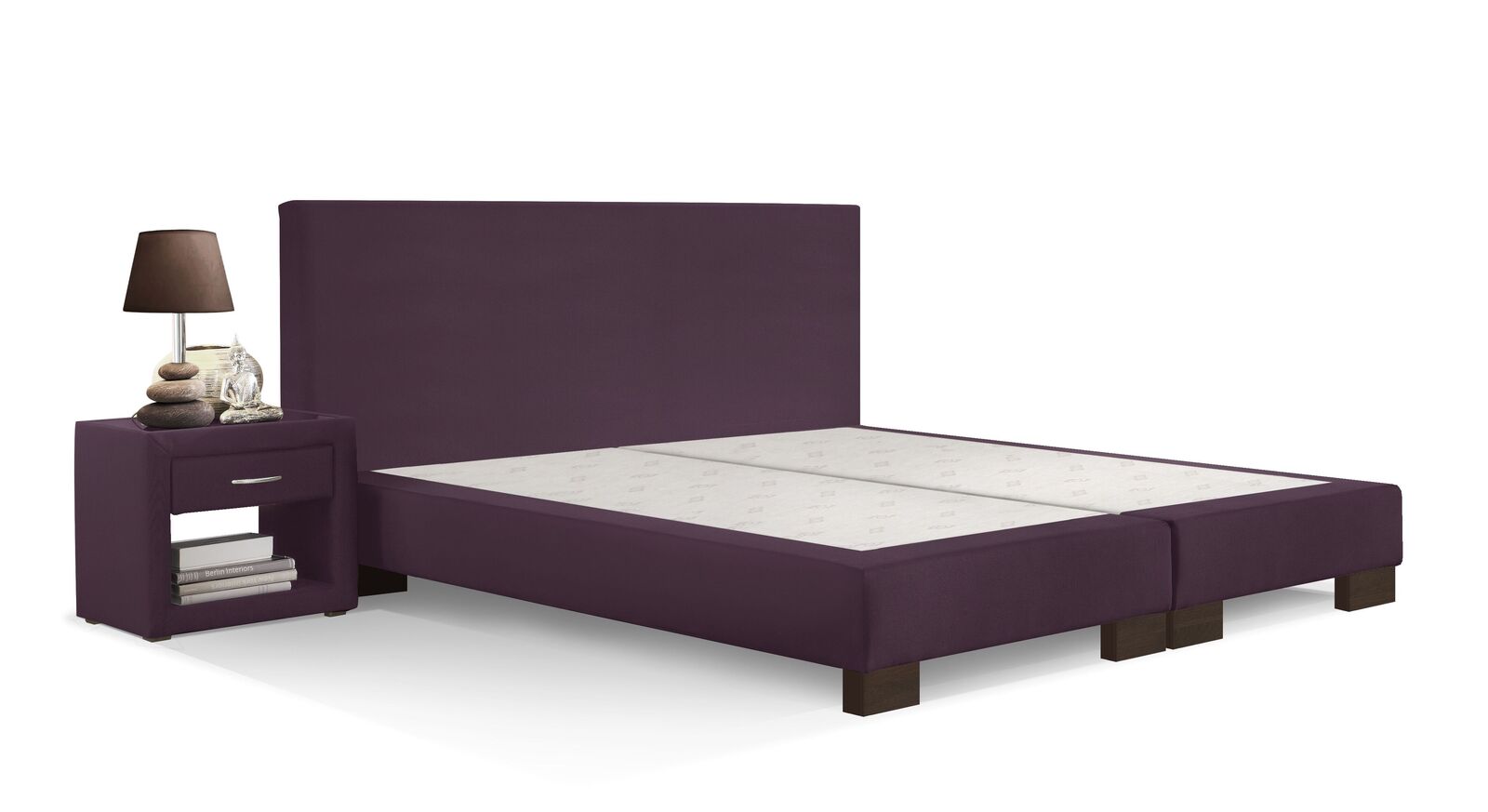 Eine warme Ausstrahlung erhält die Boxspring-Base "Polar" mit einem Bezug in Beere und wengefarbenen Beinen.