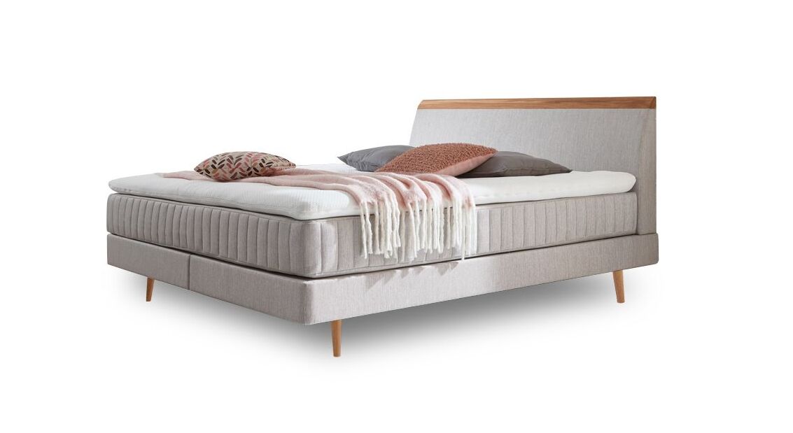 Das charmante Skandi-Boxspringbett "Akela" – hier mit Webstoffbezug in Hellgrau.