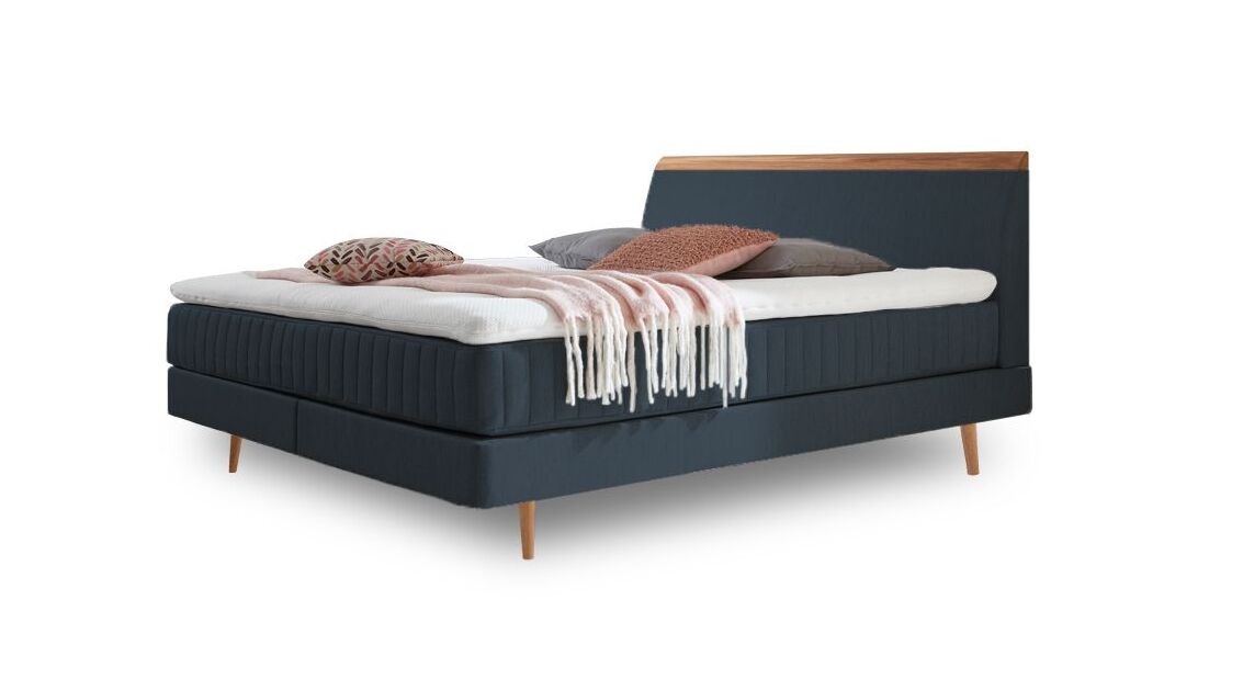 Das charmante Skandi-Boxspringbett "Akela" – hier mit Webstoffbezug in Petrol.