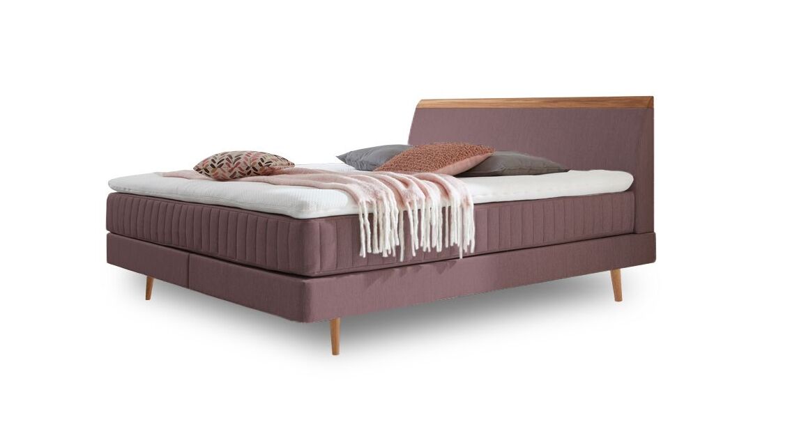 Das charmante Skandi-Boxspringbett "Akela" – hier mit Webstoffbezug in Rosa.