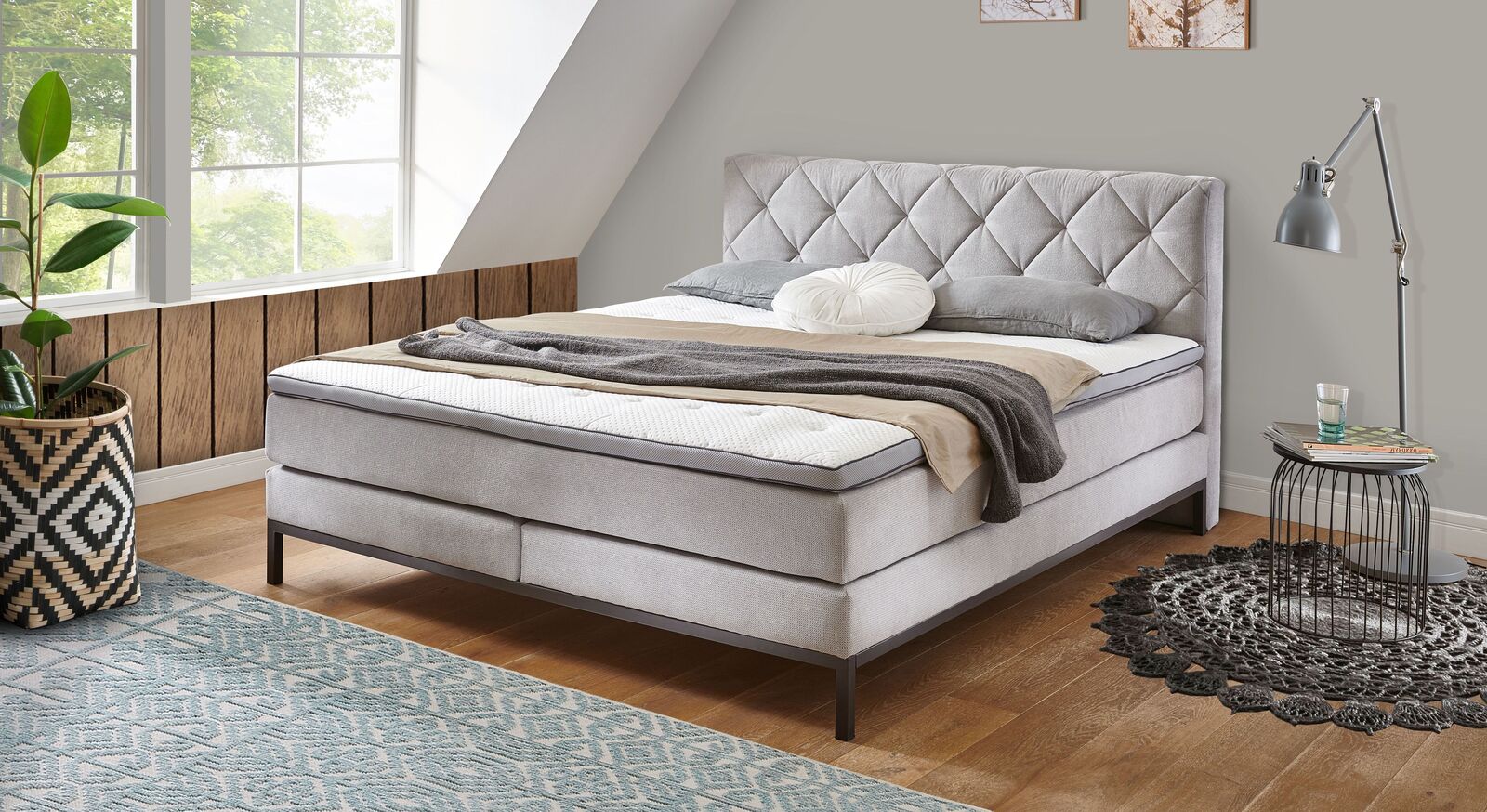 Lassen Sie sich vom romantischen Boxspringbett "Arjen" mit hellgrauem Webstoffbezug ins Land der Träume entführen.