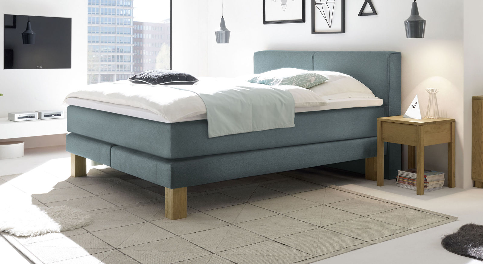 Der Bezug aus blaugrauem Fischgrät-Velours verleiht dem Boxspringbett "Coro" nordische Eleganz.