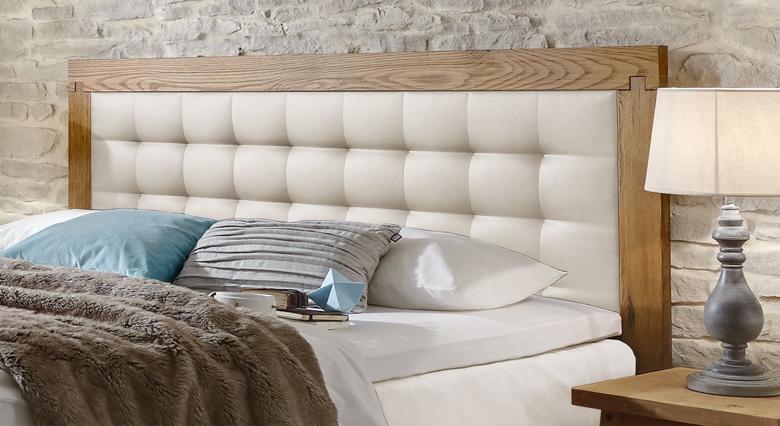 Das gesteppte Kopfteil aus Kunstleder wird von einem massiven Wildeichenrahmen umgeben.