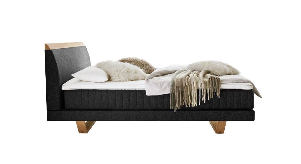 Das elegante Boxspringbett überzeugt mit seiner niedrigen Box und einer vertikal gesteppten Matratze.