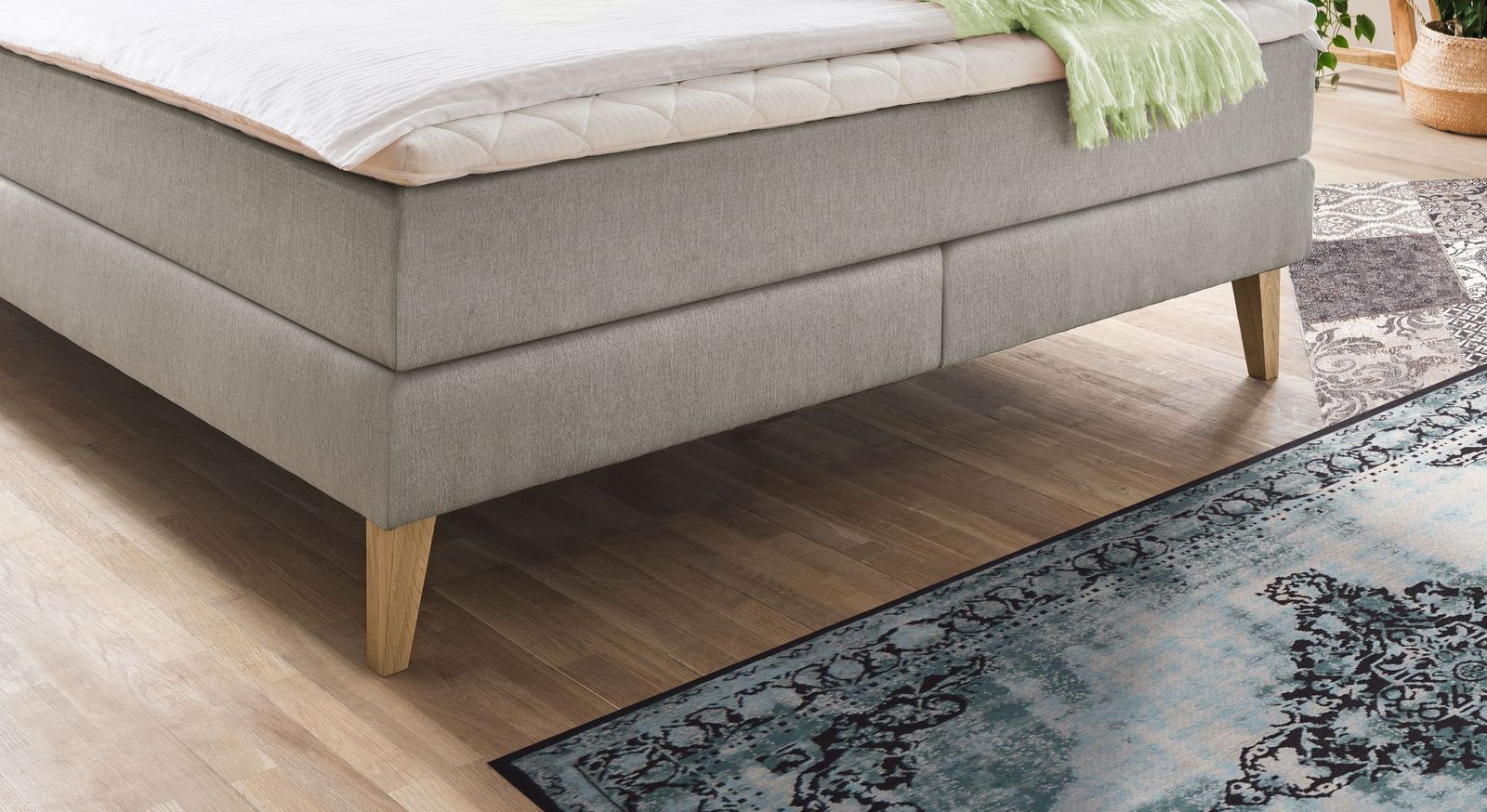 Für den skandinavischen Look sorgen die ausgestellten, konisch zulaufenden Füße aus eichefarbig gebeiztem Massivholz.