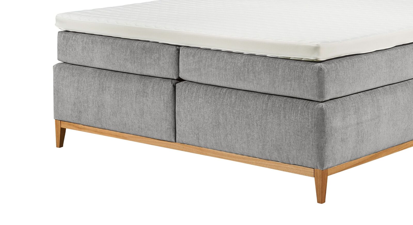 Das Untergestell mit den zierlichen Bettbeinen aus Massivholz lässt das elegante Bett filigran und gemütlich erscheinen.