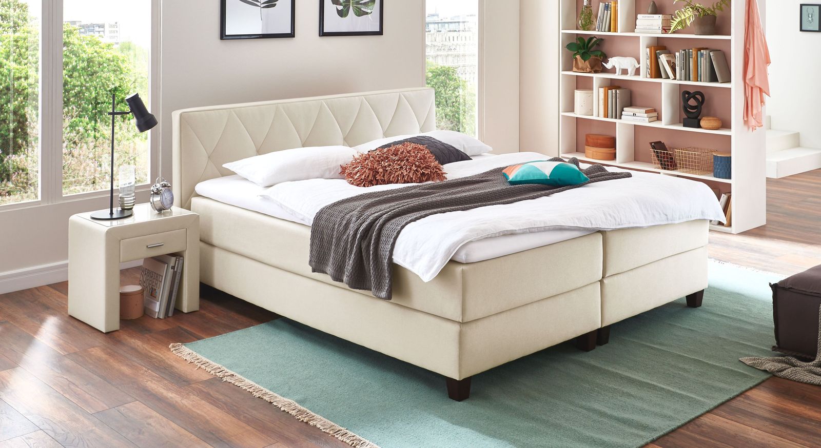 Klassisch elegant wirkt das Boxspringbett mit einem cremefarbenen Stoffbezug (Liegehöhe 53 cm).