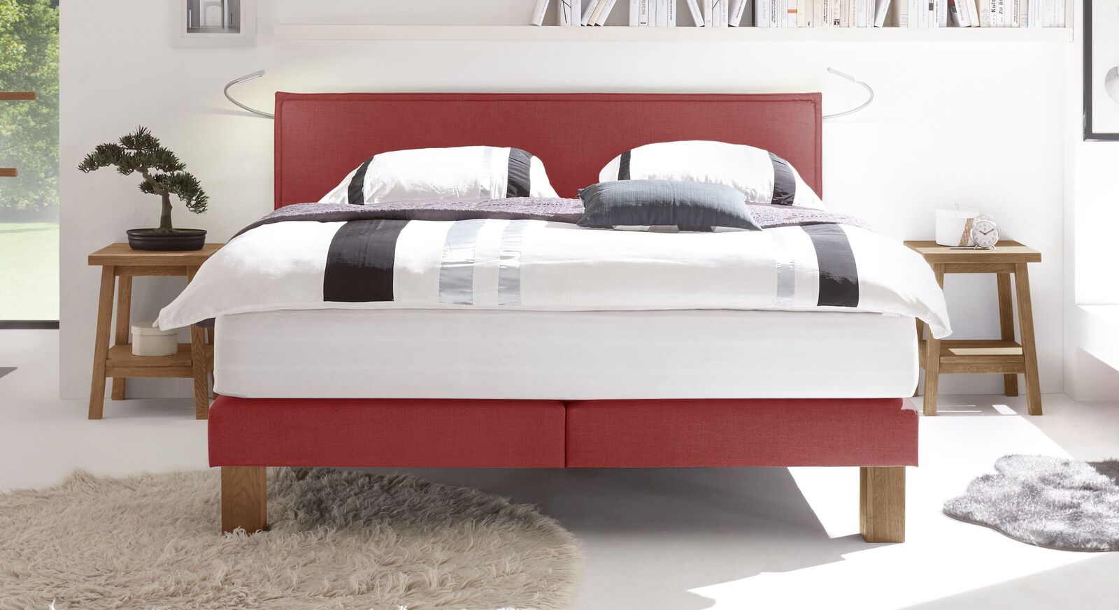 Ein absoluter Hingucker in jedem Schlafzimmer ist das Bett "Oss" mit rotem Box- und Kopfteilbezug.