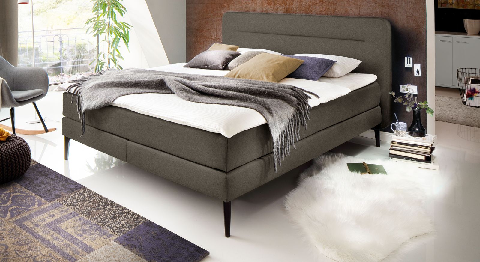 Dezent und edel wirkt das Boxspringbett "Paroldo" (hier ohne Unterleisten) in Anthrazit mit schwarzen Füßen.