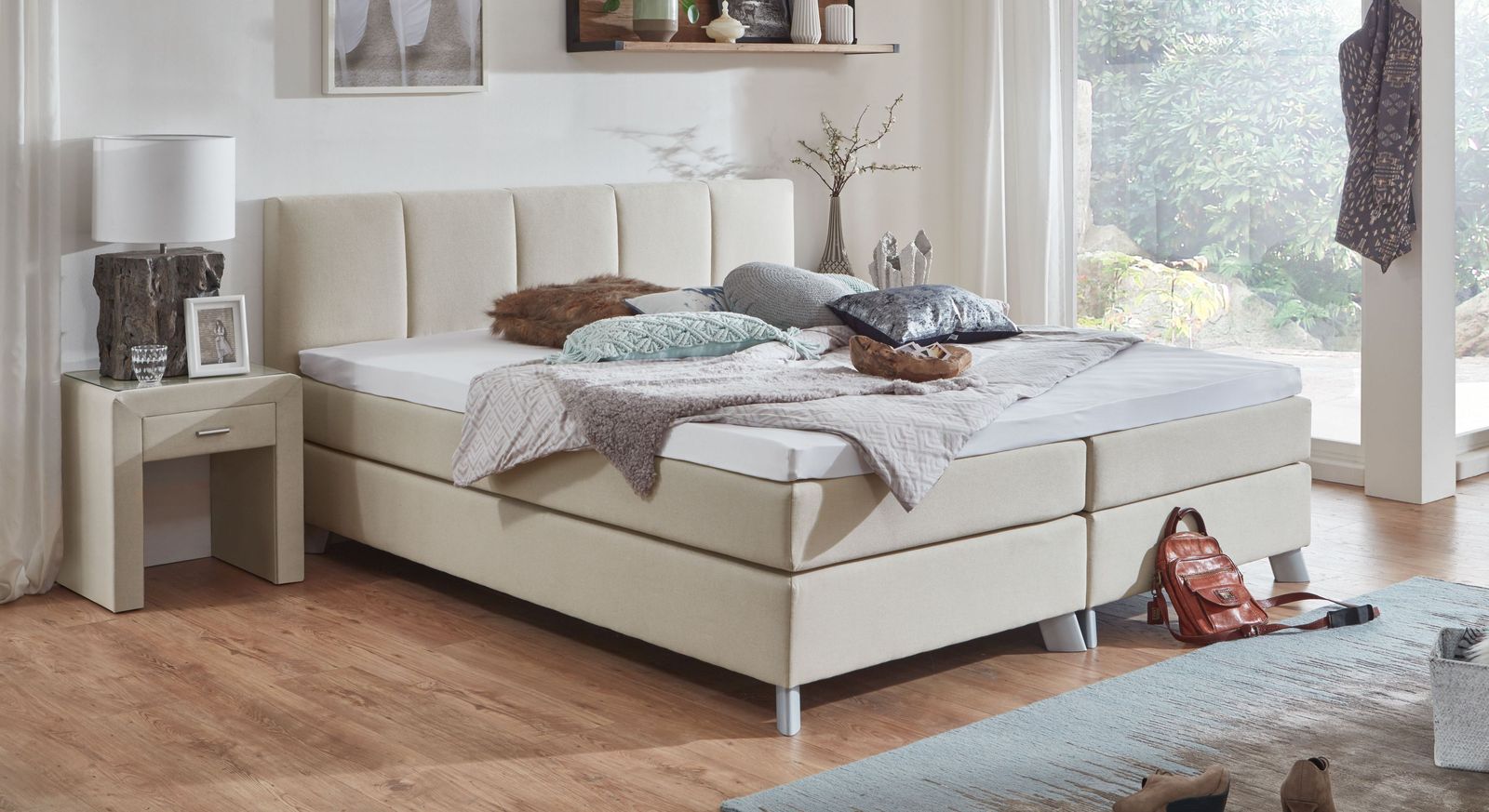 Dank des cremefarbenen Webstoffbezugs lässt sich das 53 cm hohe Bett mit vielen Farben kombinieren.