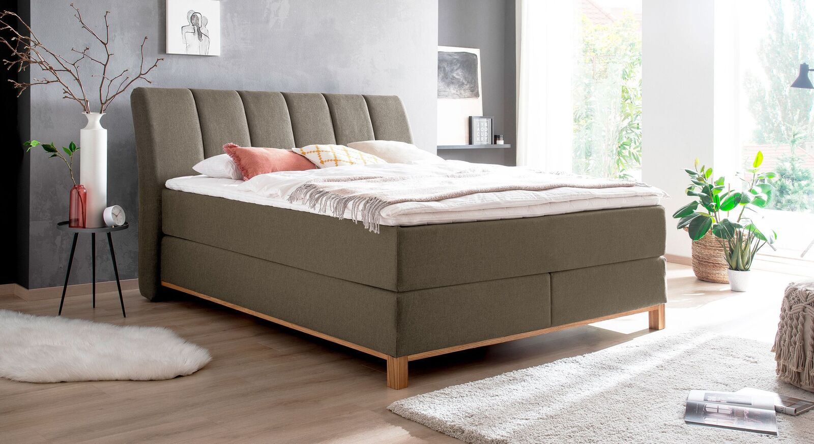 Um die natürliche Ausstrahlung des Boxspringbettes "Rivelino" zu unterstreichen, eignet sich der braune Webstoffbezug.