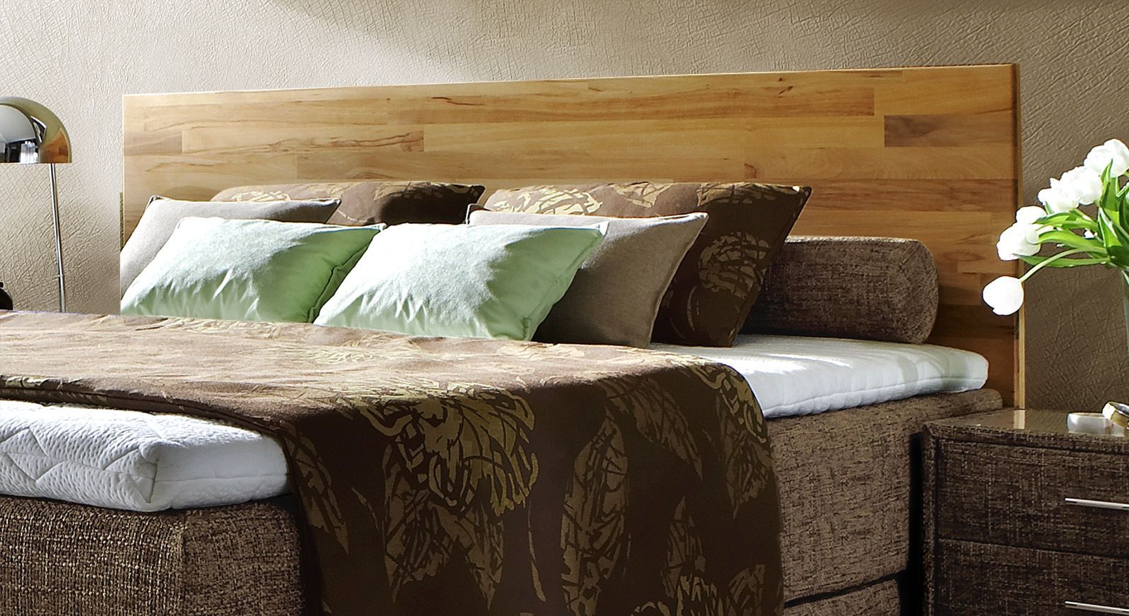 Das Kopfteil aus Buche verleiht dem Boxspringbett eine hochwertige Optik.