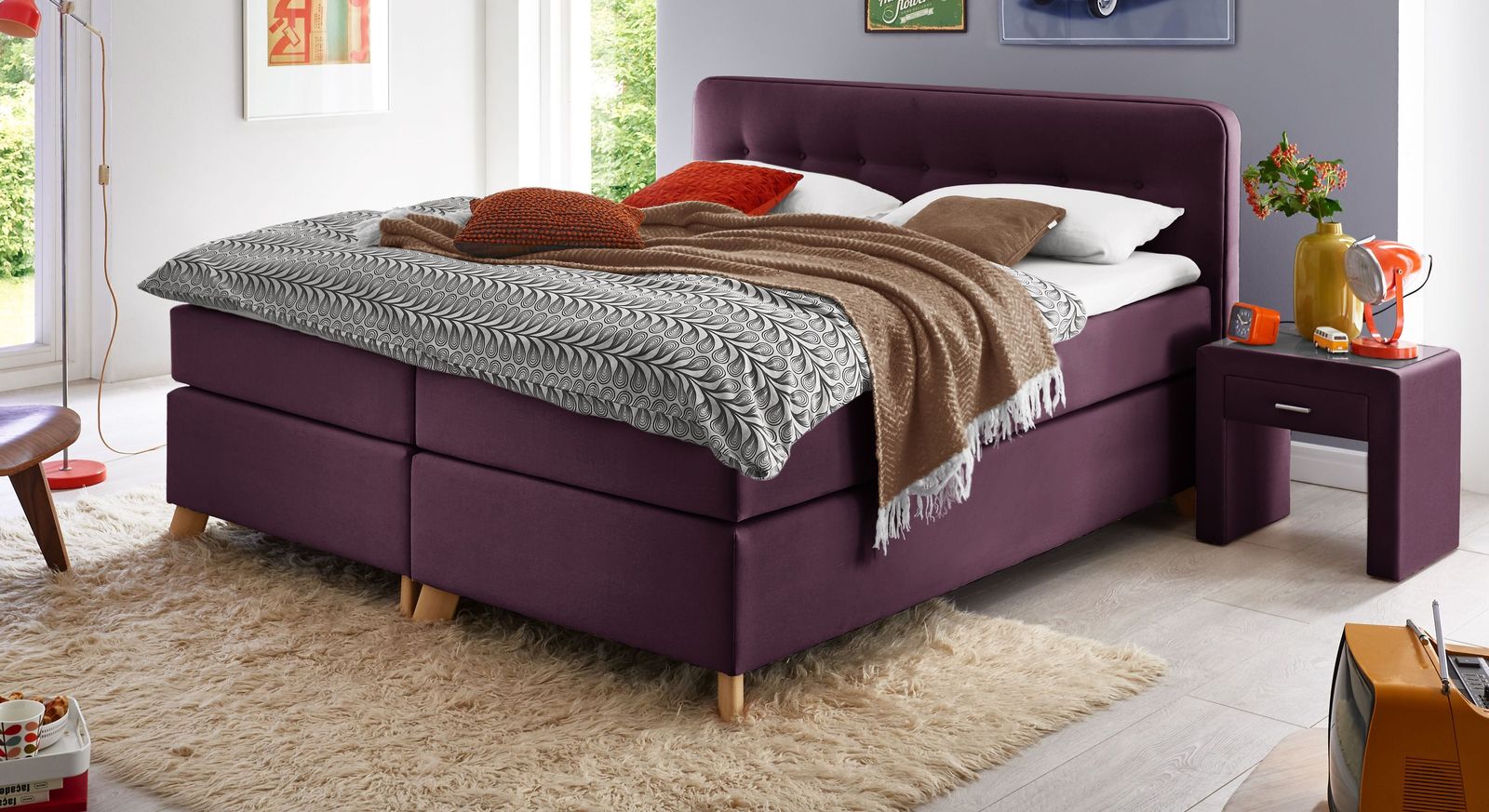 Für ein buntes Einrichtungskonzept: das Boxspringbett (hier 66 cm Höhe) im Farbton Beere.