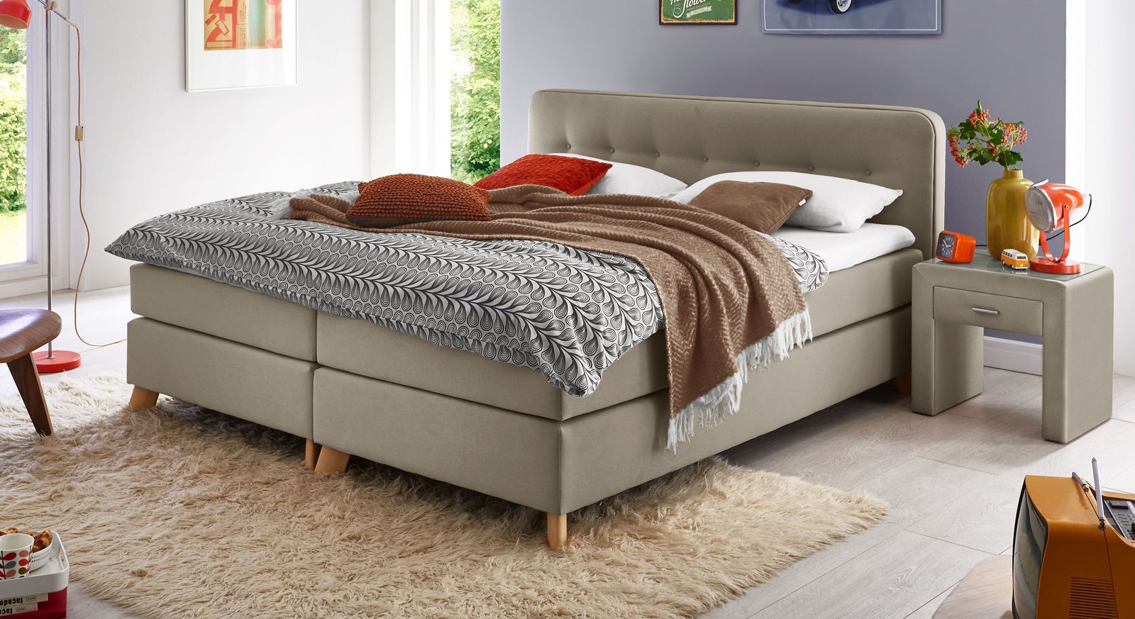 Ein aktueller Trend fürs Schlafzimmer: das modisch niedrige Bett, gehüllt in einen taupefarbenen Webstoff.