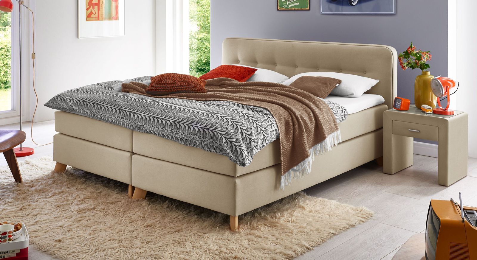 Im naturfarbenen Gewand wirkt das Boxspringbett (hier 53 cm Höhe) modisch und einladend.