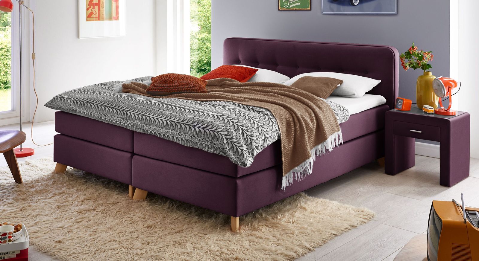 Moderne Form- und Farbgebung – das niedrige Bett "Summerford" in der modischen Farbe Beere.