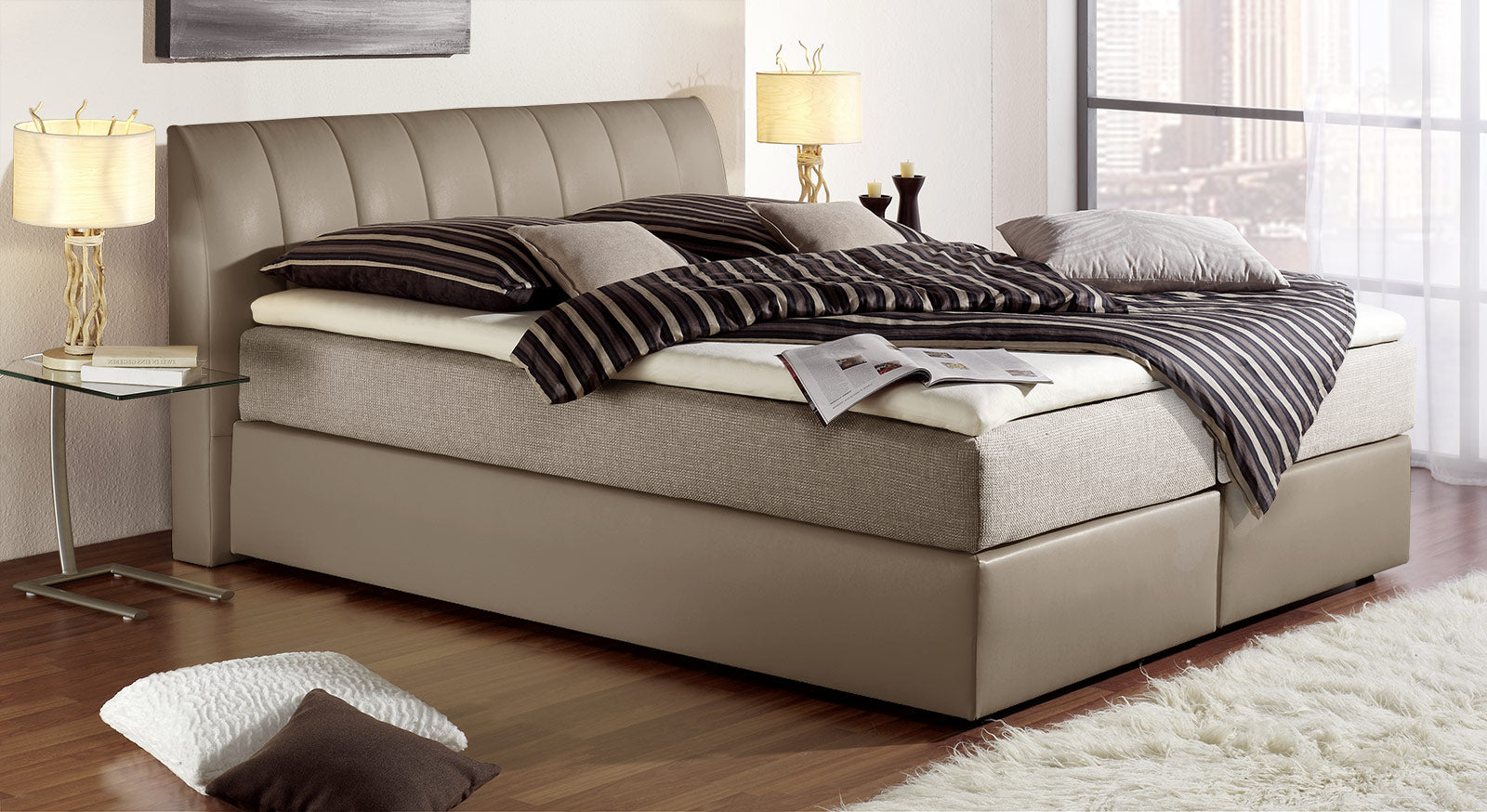 "Sydney" mit Bezug in Taupe und seitlichem Matratzenbezug aus graubeigem Webstoff.
