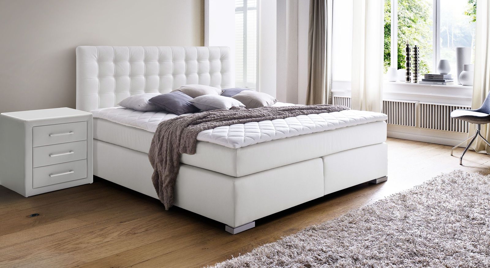 In Weiß setzt das komfortable Boxspringbett "Taimea" einen hellen Akzent in dunklen Räumen.
