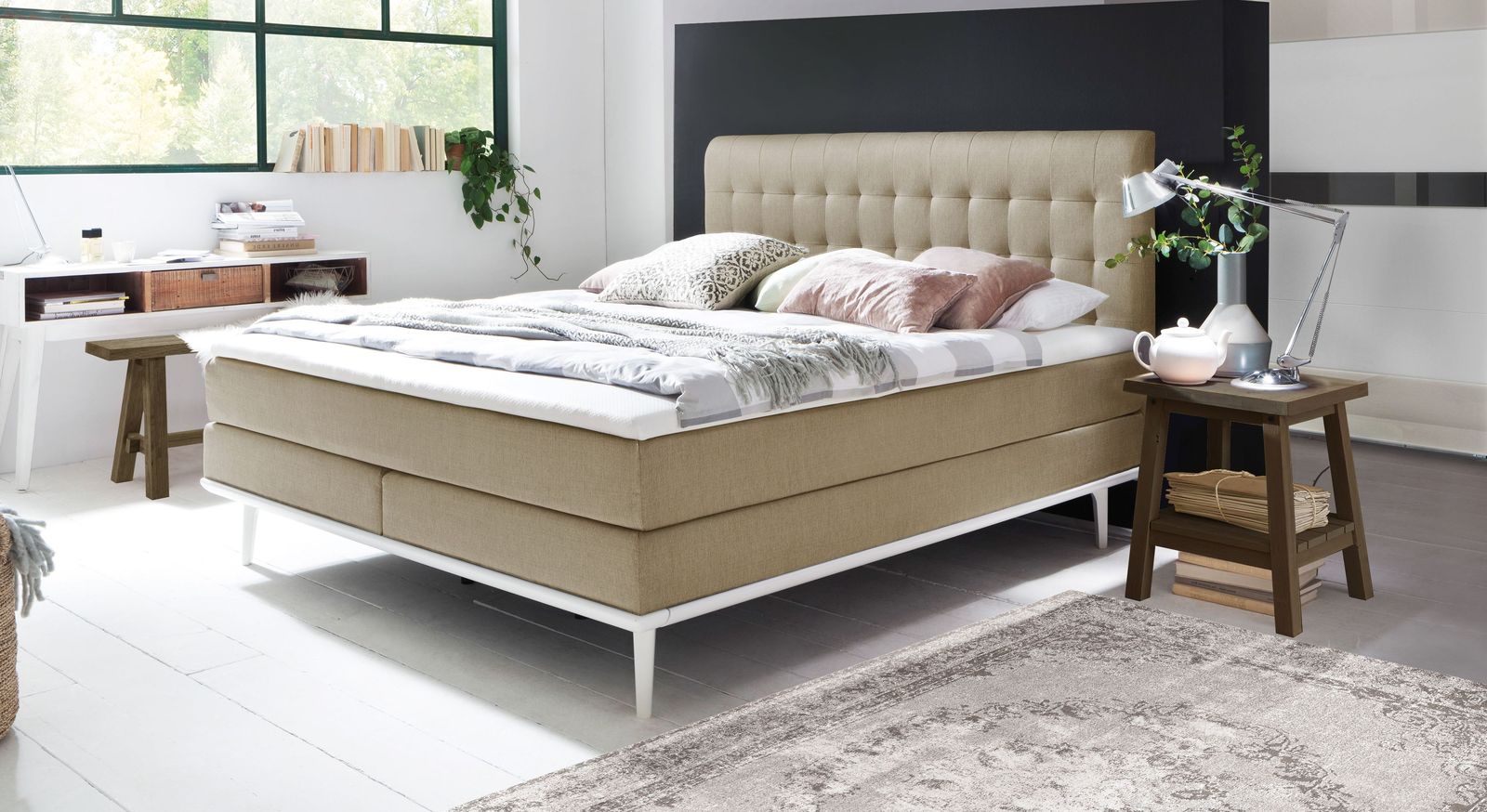 Das mittelweiche Boxspringbett "Tromello" – hier in Beige mit weißen Füßen und Unterleisten.