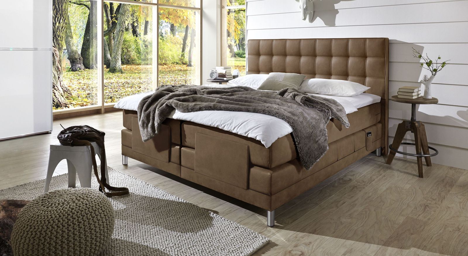 Das elektrisch verstellbare Boxspringbett "Zamora Elektro" (hier in Hellbraun) mit hohem Kopfteil.