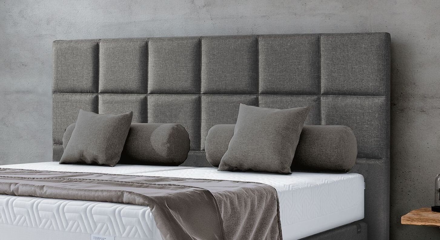 Das Kopfteil ist mit einem grauen Webstoff bezogen und in Karos abgesteppt.