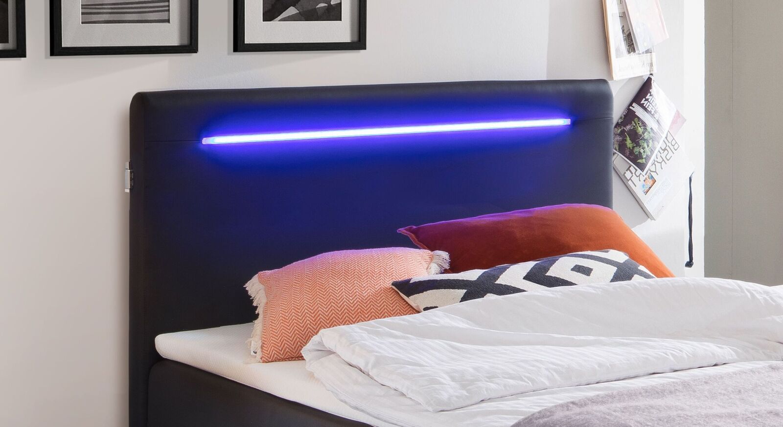 Das hohe Kopfteil des Bettkasten-Boxspringbettes "Andrik" ist mit einer attraktiven LED-Lichtschiene versehen.