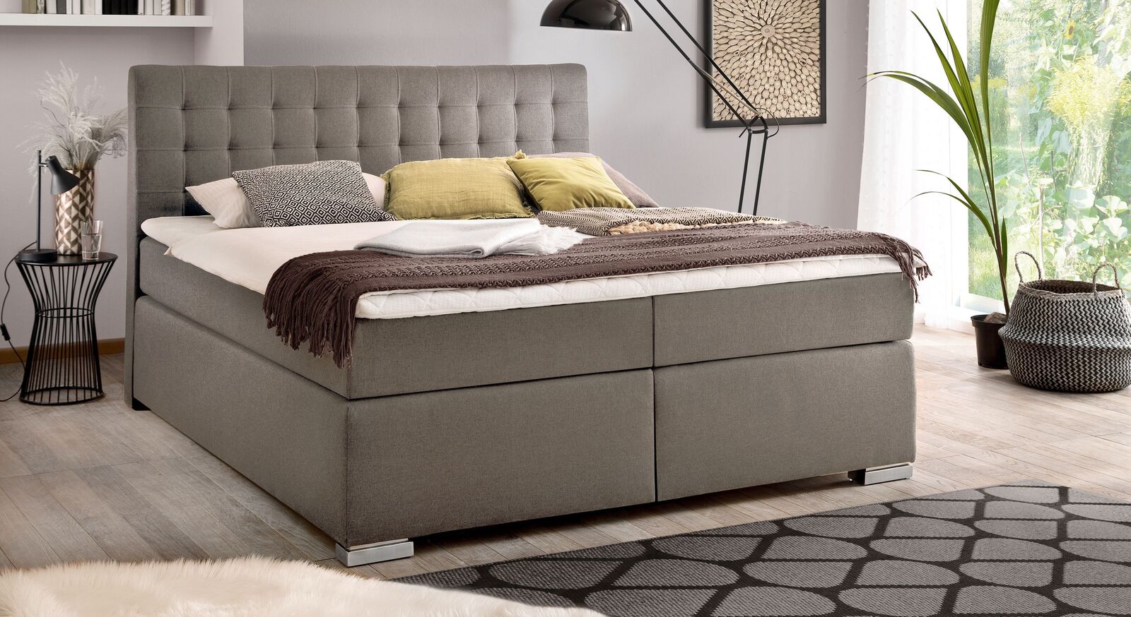 Klassisches Design und hohe Funktionalit&auml;t: das Bettkasten-Boxspringbett "Santera" &ndash; hier mit grobem Webstoff in Braun sowie mit Metallf&uuml;&szlig;en.