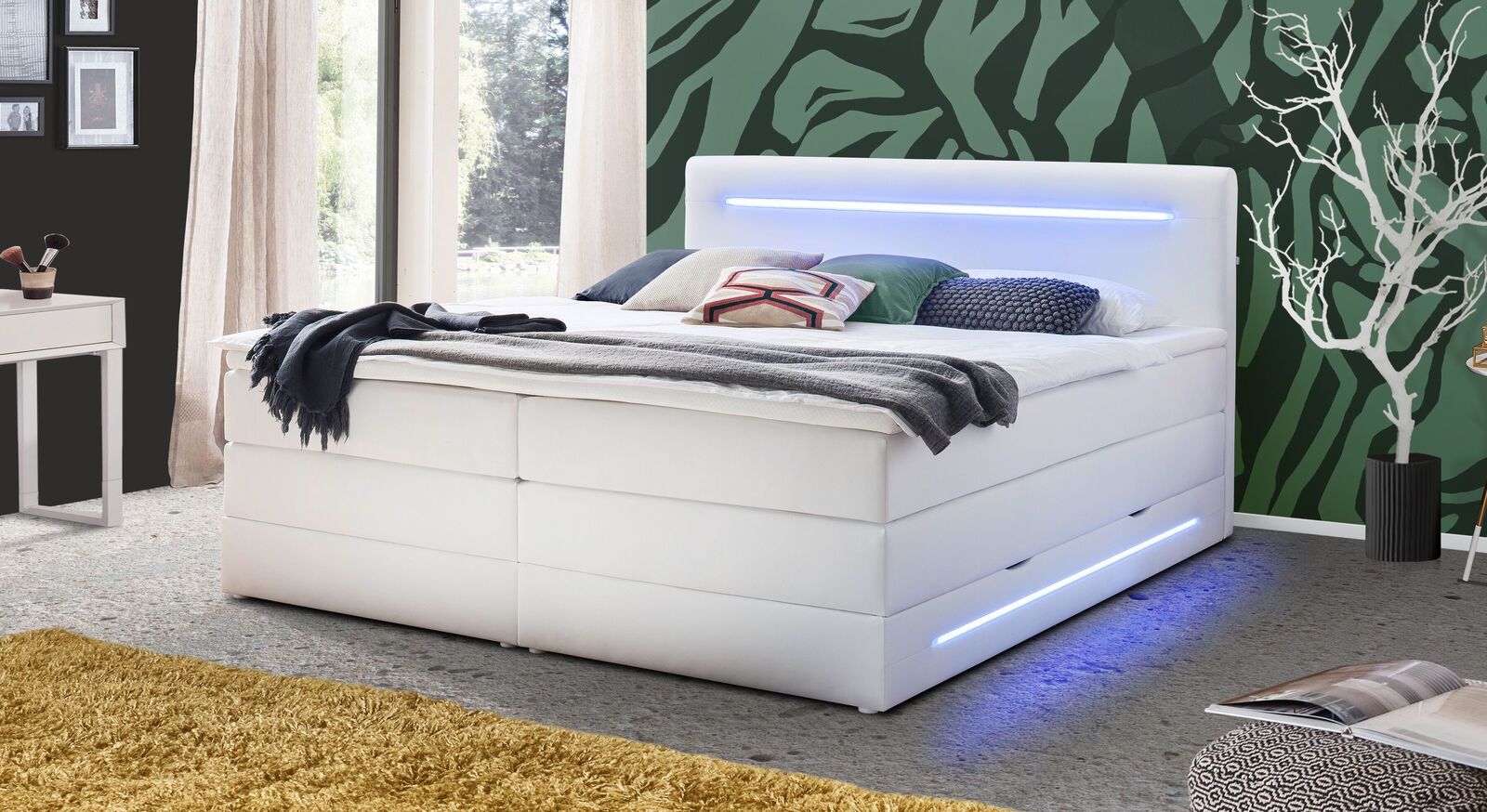 Hoher Liegekomfort und durchdachte Funktionalit&auml;t vereint: das Bettkasten-Boxspringbett "Tarasco" in wei&szlig;em Kunstleder mit LED-Beleuchtung.