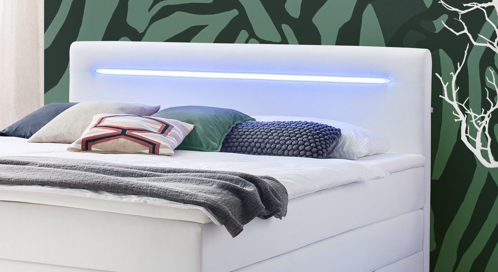 In das gepolsterte Kopfteil ist eine LED-Leiste eingelassen, die f&uuml;r stimmungsvolle Lichteffekte im Schlafzimmer sorgt.