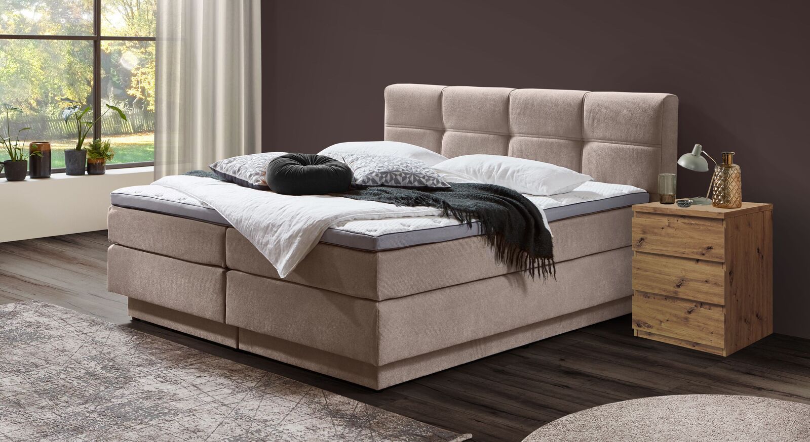 Das volumin&ouml;s gepolsterte Bettkasten-Boxspringbett "Torin" mit naturfarbenem Webstoffbezug und integriertem Stauraum.