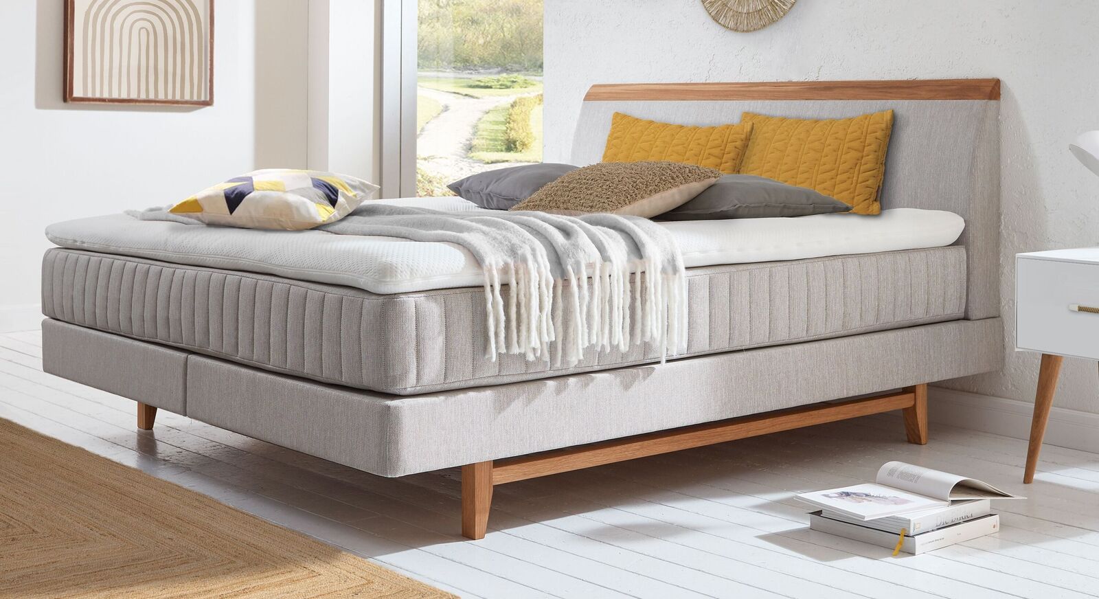 Skandinavisches Design in seiner sch&ouml;nsten Form: das Boxspringbett "Akela" mit gesteppter Matratze und Holz-Elementen.