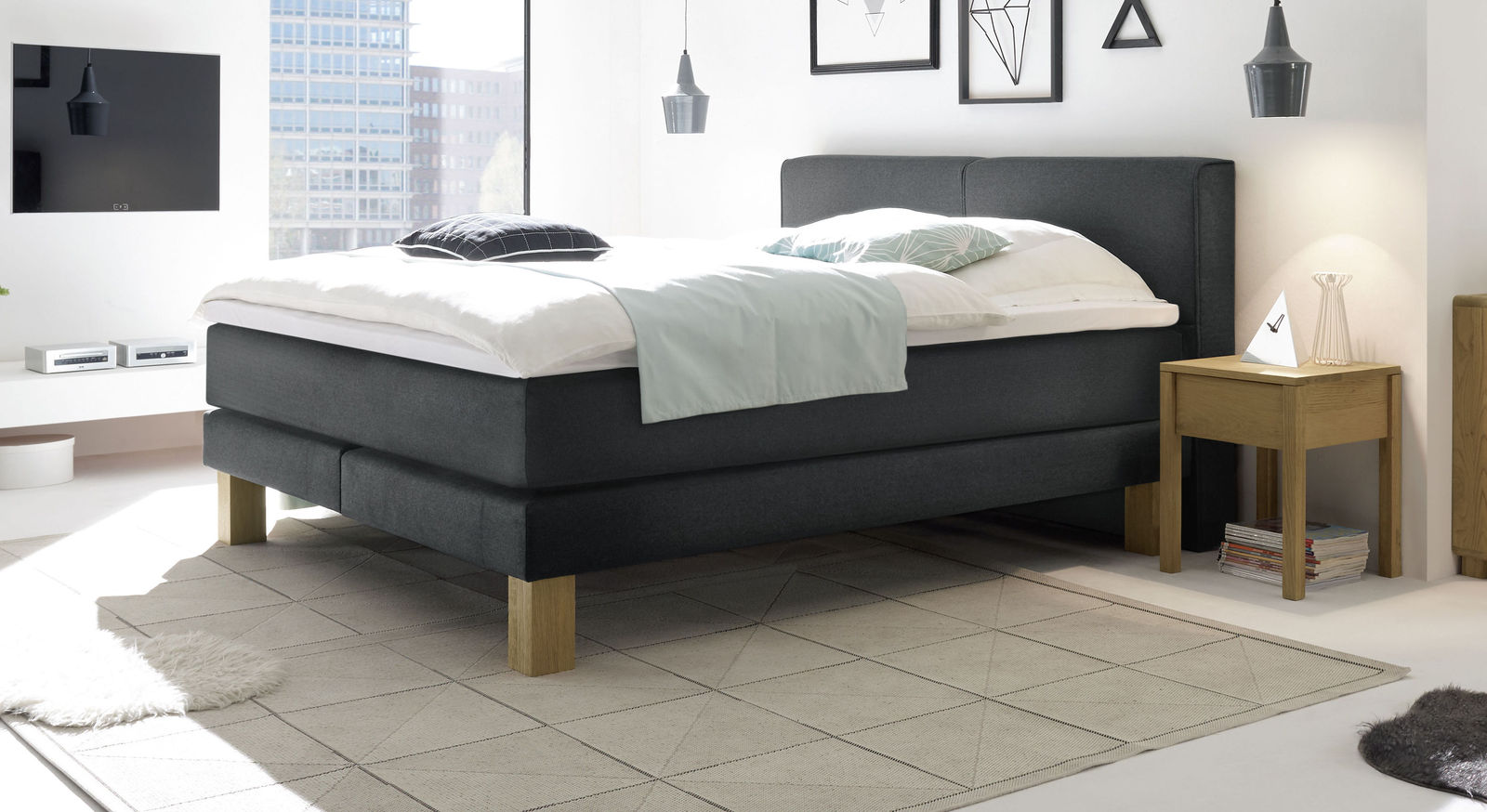 Das individuell anpassbare Boxspringbett "Coro" ist in weichen Fischgr&auml;t-Velours (hier in Anthrazit) geh&uuml;llt.