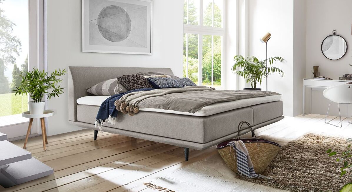 Das luftige Boxspringbett "Lajana" begeistert mit seiner geradlinigen Optik, die an ein skandinavisches Polsterbett erinnert.