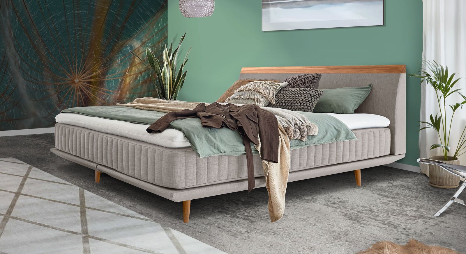 Frei im Raum platzierbar: das Boxspringbett "Mavilla" mit vertikal gesteppter Matratze und eleganten Holzelementen.