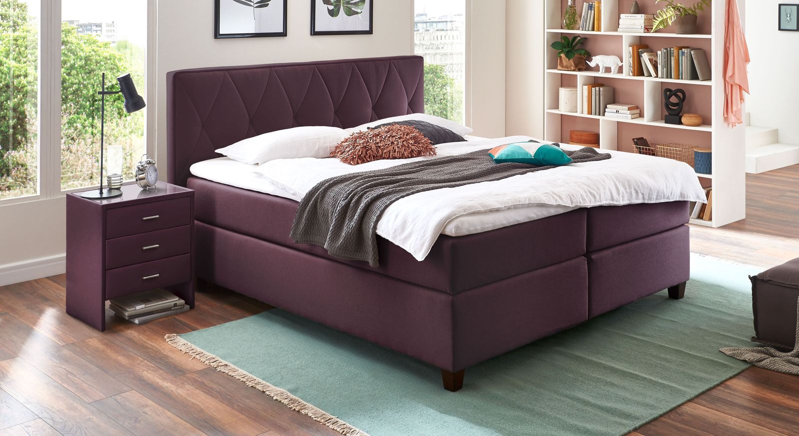 Das Boxspringbett "Midway" (hier in der hohen Variante in Beere) begeistert mit einer flexiblen Ausstattung.