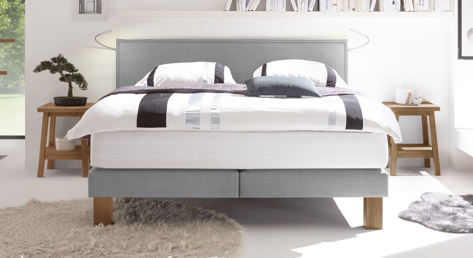 In hellgrauem Samtvelours f&uuml;gt sich das Boxspringbett "Oss" elegant in reduzierte Einrichtungsstile ein.