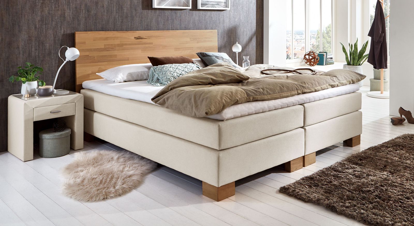 Zeitlos elegant: das niedrige Boxspringbett "Peachland" in cremefarbener Stoffumh&uuml;llung.
