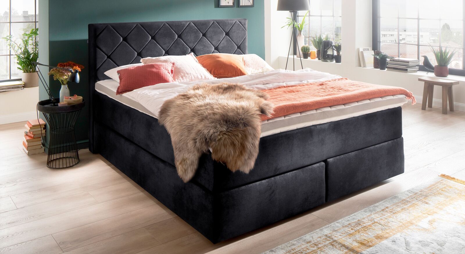Das extravagante Boxspringbett "Severino" mit weichem Bezug aus Velours-Lederimitat (hier in Schwarz) und Rautensteppung am Kopfteil.