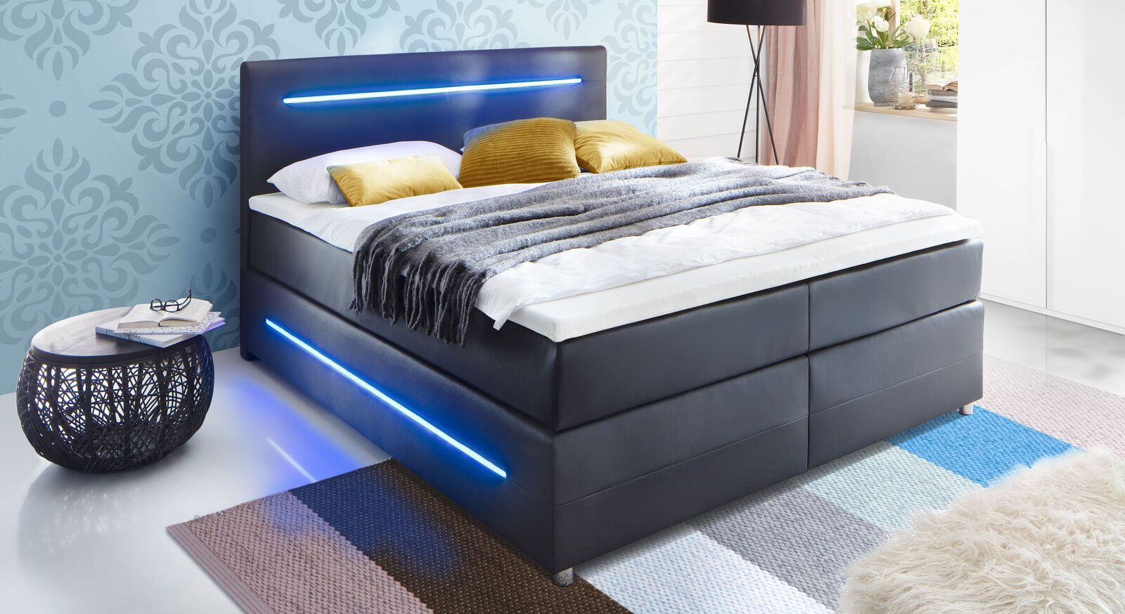 Das moderne Boxspringbett "Shelford" in schwarzem Kunstleder mit stylischer LED-Beleuchtung an der Box und am Kopfteil.