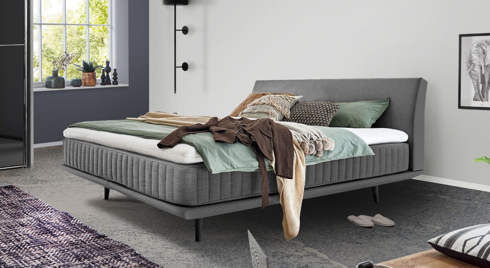 Das elegante Boxspringbett "Valtor" begeistert mit seiner niedrigen Box, einer vertikal gesteppten Matratze sowie dem gebogenen Kopfteil.