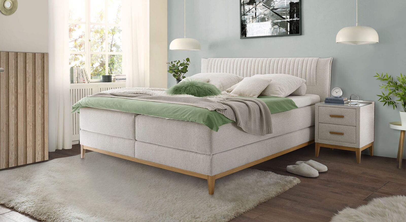 Elegantes Design und gem&uuml;tliche Optik: das Boxspringbett "Xander" mit cremefarbigem Webstoffbezug und filigranem Untergestell aus Massivholz.