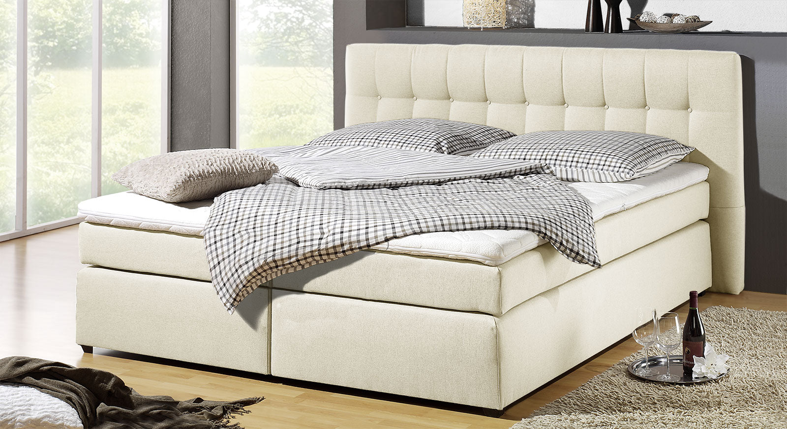 Das Markenzeichen des Boxspringbettes "Chicago" (hier in Creme) ist das gro&szlig;e Polsterkopfteil.